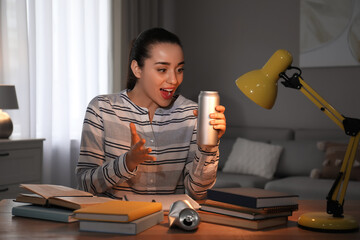 Poster - Emotional young woman with energy drink studying at home