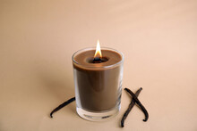 Beautiful Candle With Wooden Wick And Vanilla Sticks On Beige Background