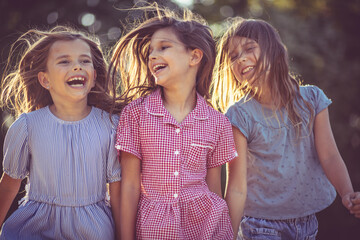 Portrait of smiling kids. Three little girls spending time outside.