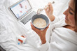 © Viacheslav Yakobchuk - Beautiful attractive woman having breakfast in the morning while spending time at the laptop