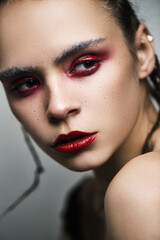 Young beautiful model with bright make up in red colours