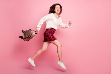 Wall Mural - Full size profile side photo of young girl happy positive smile jump up go walk run hurry isolated over pink color background