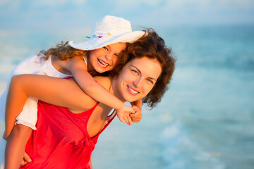 Wall Mural - Portrait of happy mother and little daughter on sunny beach on Maldives at summer vacation. Family on the beach concept.