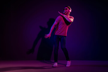 Poster - Full length body size view of attractive funny cheerful guy listening hit sound dancing isolated over dark neon violet color background