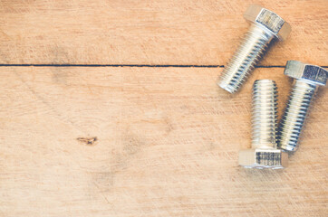 Poster - Top view of long silver bolts on a wooden surface