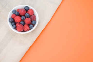 Poster - Top view of fresh blueberry and raspberry on a white bowl