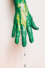 Hand Covered In Green Paint That Is Dripping From The Fingers