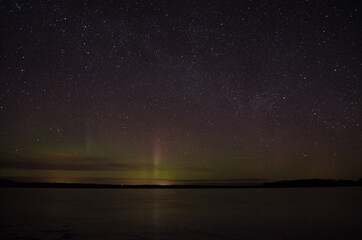 northern lights aurora borealis over pond in latvia.