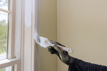Hand Of Worker With Gloves In The Painting Window Molding Trim