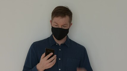 Poster - Portrait of man wearing face mask and using phone while looking sad