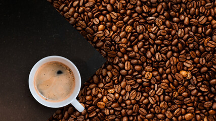 Cup of coffee with coffee beans on table