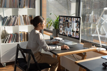 Wall Mural - rear view indian businesswoman involved in internet meeting with colleagues, group video call, diver