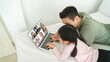 © eakgrungenerd - Asian family, father and daughter using laptop with connect video call with many people work from home, online communication concept.