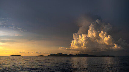 Wall Mural - Sun light Shines against the clouds at sunset on the sea.