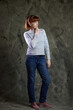 © Вячеслав Чичаев - Portrait of a Caucasian woman in full growth in jeans in a studio on gray background. High resolution photos