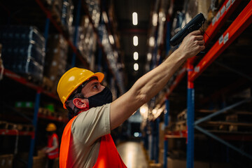 Wall Mural - Man using bar-code reader in warehouse