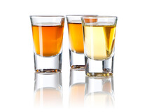 Three Shot Glasses With Different Spirits on white background