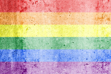 Rainbow LGBTQ or gay pride flag on decorative plaster or concrete texture. Abstract background.