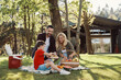© gstockstudio - Happy young mother and father with little boy smiling while having picnic outdoors