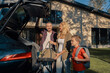 © gstockstudio - Happy young family packing stuff into the car and smiling while standing near house