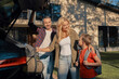 © gstockstudio - Happy young family packing stuff into the car and smiling while standing near house