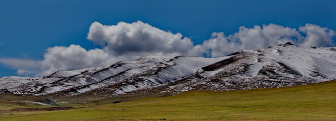 Wall Mural - Western Mongolia. The clouds on the snow-covered high-altitude steppes seem very low due to the high altitude (2500-3000m above sea level).