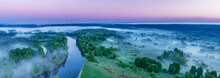 Smoky Morning Mist Over The River. Beautiful Panoramic View Of River And Green Banks Of The River In The Early Summer Morning.