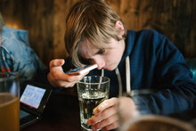 USA, California, San Francisco, Boy Holding Smart Phone And Glass Of Water