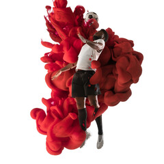 Wall Mural - Young man professional football soccer player in explosion of red colored neon luiquid fluid isolated on white background.