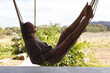 © Wavebreak Media - Smiling caucasian woman lying in hammock on sunny cottage terrace, looking to garden