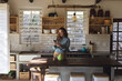 © Wavebreak Media - Happy caucasian woman standing in cottage kitchen using smartphone and smiling