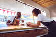 © Wavebreak Media - Smiling diverse couple leaning on counter using tablet in food truck