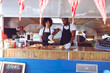 © Wavebreak Media - Diverse couple preparing hot dogs behind counter in food truck
