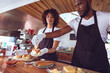 © Wavebreak Media - Diverse couple preparing hot dogs behind counter in food truck