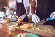© Wavebreak Media - Midsection of mixed race woman grating cheese behind counter in food truck