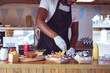 © Wavebreak Media - Midsection of african american man in food truck preparing order with hotdogs on worktop