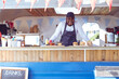 © Wavebreak Media - Portrait of smiling african american man in food truck with hamburgers on worktop