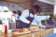 © Wavebreak Media - African american man in food truck preparing order with hamburgers on worktop