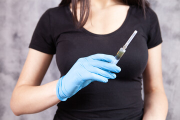 Wall Mural - woman holding syringe with rubber gloves