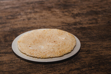 Paraguayan mbeju on top of a plate on a wooden table.