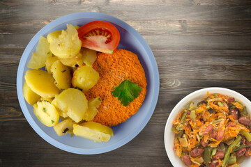 Wall Mural - meatball with potatoes on a wooden background