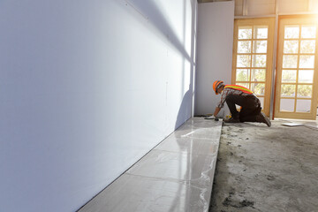 Laying Ceramic Tiles.Home tile improvement - handyman with level.Tiler works with flooring