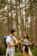 © BGStock72 - Smiling young couple walking with backpacks in the forest