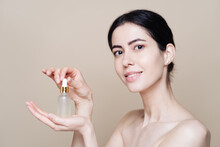 Woman Holds Hyaluronic Serum. Photo Of Pretty Woman With Perfect Skin On Beige Background. Beauty Product Presentation