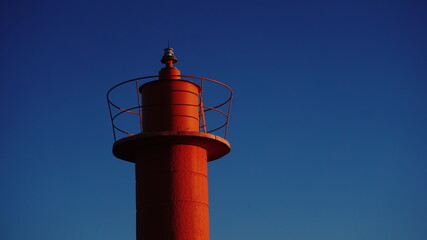 red lighthouse against blue sky