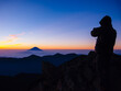 朝焼けに染まる富士山と撮影者のシルエット