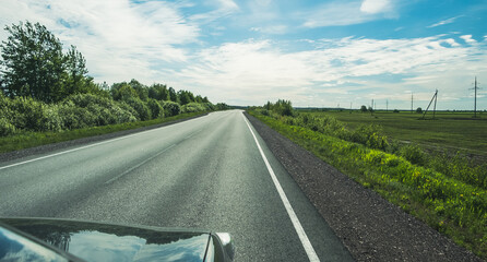 Wall Mural - The road among the Karelian taiga. Pine forest on the side of the road. Trip to Karelia. Highway among the trees. Driving on a trip to beautiful places. Karelia. Day.