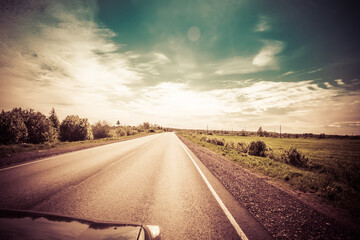 Wall Mural - The road among the Karelian taiga. Pine forest on the side of the road. Trip to Karelia. Highway among the trees. Driving on a trip to beautiful places. Karelia. Day.