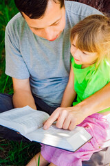 Sticker - happy father with a child reading a book on the nature of the Bible