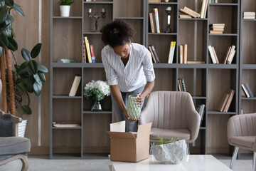 happy young african american woman taking vase from cardboard box, feeling excited of getting wished